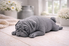 Load image into Gallery viewer, A detailed handmade vegan soap gift, sculpted in the shape of a pug dog lying flat on its stomach in a sleeping position, showing realistic skin folds and fur texture, displayed on a light wooden surface. Handmade in Blackpool 
