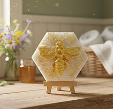 Load image into Gallery viewer, handmade vegan soap gift featuring a detailed honey bee in shimmering gold, displayed on a wooden easel I. A farmhouse decor background 
