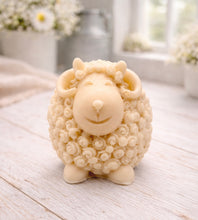 Load image into Gallery viewer, A highly detailed handmade vegan soap sculpted in the shape of a sturdy ram with a thick coat of tight, curly wool and large, elegant curved horns, displayed on a light wooden surface in a bright farmhouse setting.
