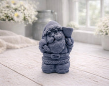 Load image into Gallery viewer, A highly detailed 3D handmade vegan soap featuring a Father Christmas carrying a large sack of gifts over his shoulder and holding a bell, featuring an intricate curly beard and fur-trimmed suit, set against a festive holiday background.
