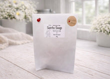Load image into Gallery viewer, White soap packaging with branding on a light wooden surface
