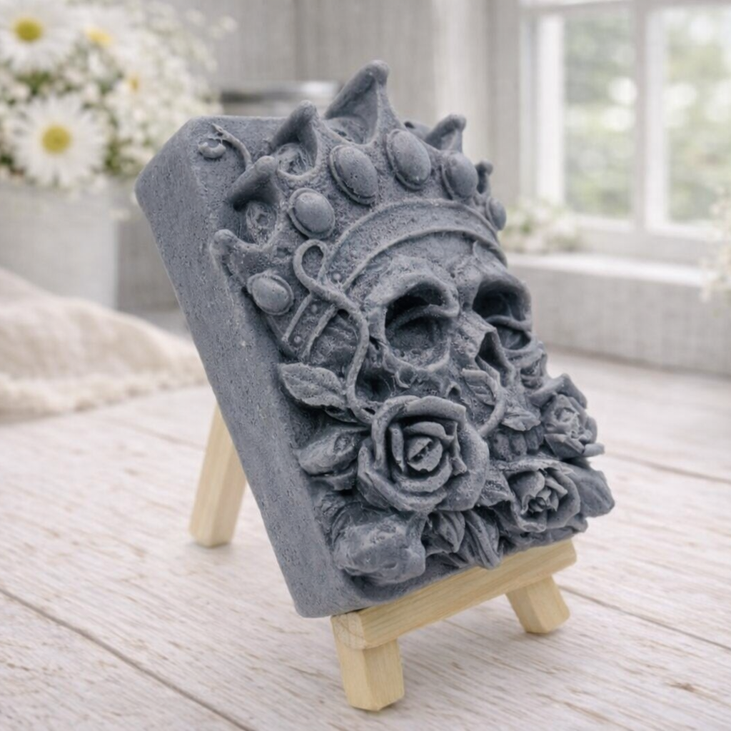 handmade vegan soap gift featuring a detailed relief of a skull wearing a crown, surrounded by a border of roses, displayed on a small wooden easel.
