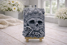 Load image into Gallery viewer, handmade vegan soap gift featuring a detailed relief of a skull wearing a crown, surrounded by a border of roses, displayed on a small wooden easel.
