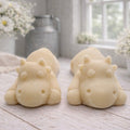 A handmade vegan soap gift set featuring two soaps sculpted into cute, sleeping cows, presented in a brown kraft box tied with a red raffia ribbon and a small ladybird embellishment.