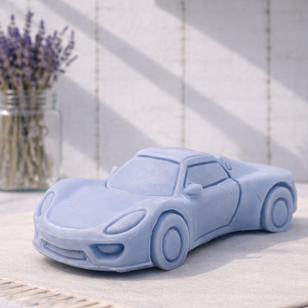 Blue sports car-shaped vegan soap gift on a light surface with a vase of lavender in the background
