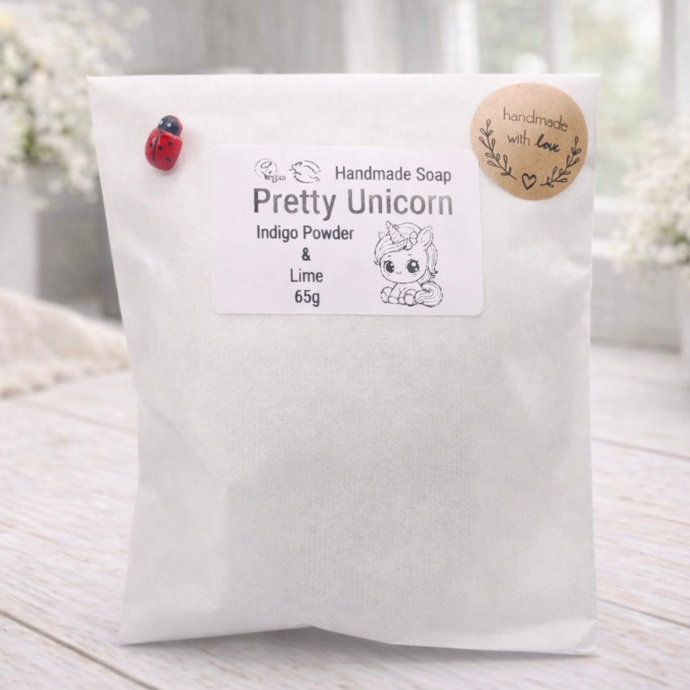 Handmade soap packaging with 'Pretty Unicorn' branding on a light wooden surface.
