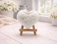 Load image into Gallery viewer, A pair of handmade vegan soaps shaped like hearts and displayed on miniature wooden easels; one heart is textured like a grey tuxedo with a bow tie and buttons, and the other is a white bridal gown heart with intricate lace patterns and a pearl necklace detail.
