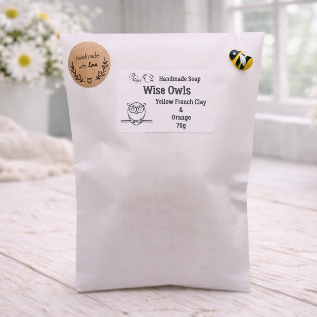 White bag with a label on a wooden surface with flowers in the background