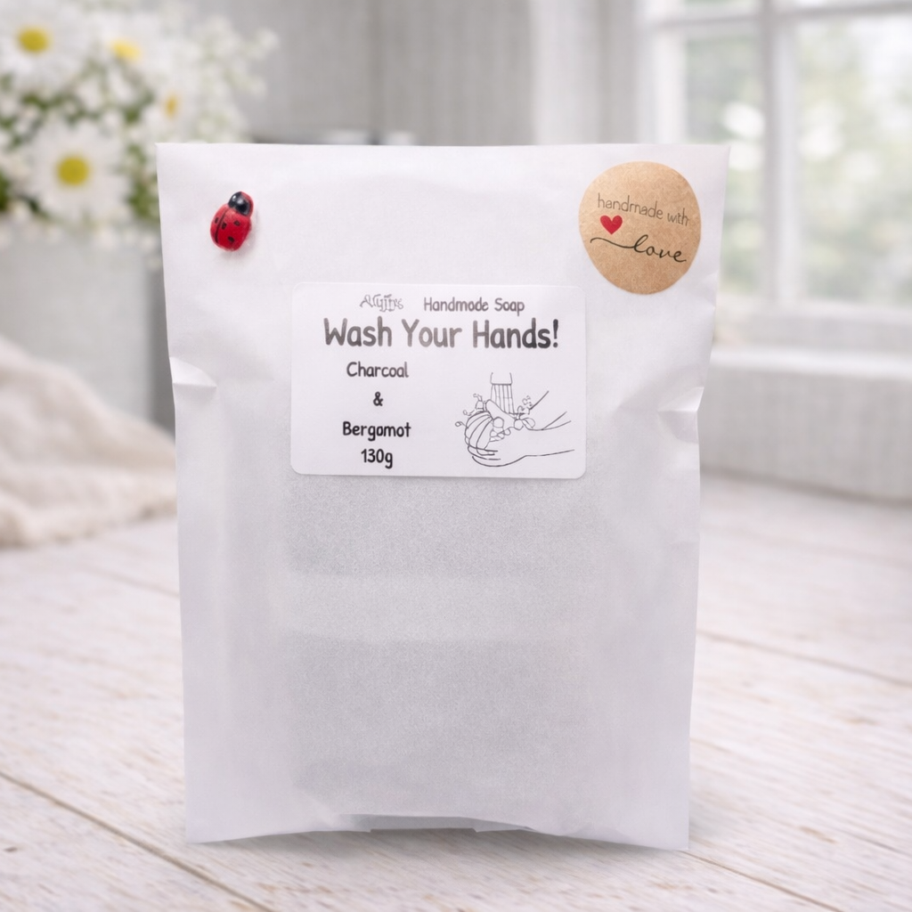 White bag labeled 'Wash Your Hands!' with decorative elements on a light wooden surface.