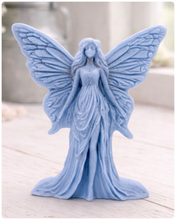 Load image into Gallery viewer, A detailed handmade vegan soap featuring an elegant fairy with large, intricate butterfly-style wings, a flowing gown, and long hair, standing against a bright farmhouse window background.
