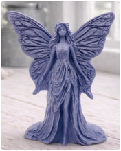 Load image into Gallery viewer, A detailed handmade vegan soap featuring an elegant fairy with large, intricate butterfly-style wings, a flowing gown, and long hair, standing against a bright farmhouse window background.
